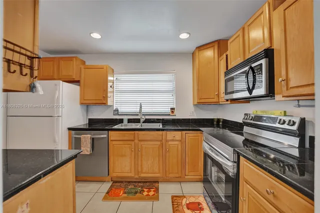 a kitchen with stainless steel appliances granite countertop a stove sink and microwave