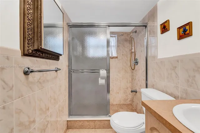 a bathroom with a shower a toilet and a sink
