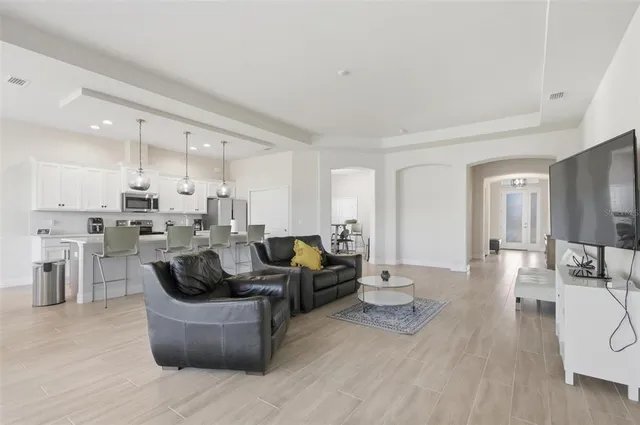 a living room with furniture and a view of kitchen