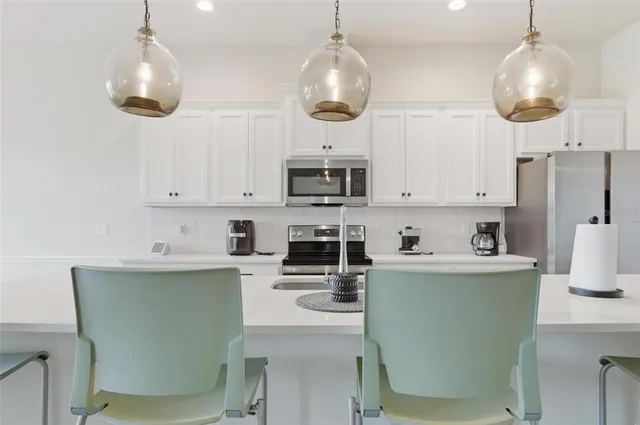 a kitchen with stainless steel appliances granite countertop a stove a sink and a refrigerator