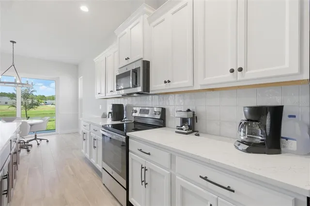 a kitchen with stainless steel appliances granite countertop a sink a stove and cabinets
