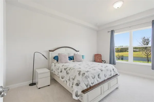 a bedroom with a bed and large windows