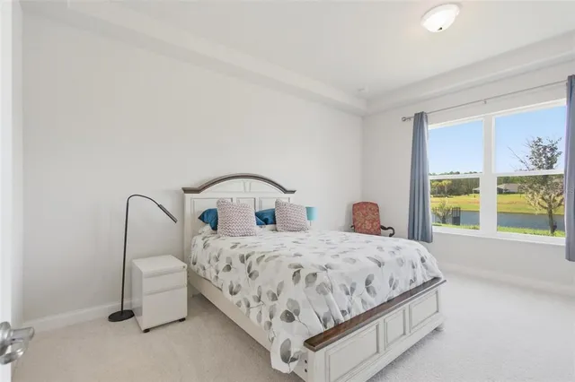 a bedroom with a bed and large windows