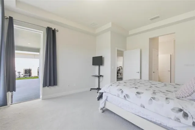 a bedroom with a bed tv and a chair