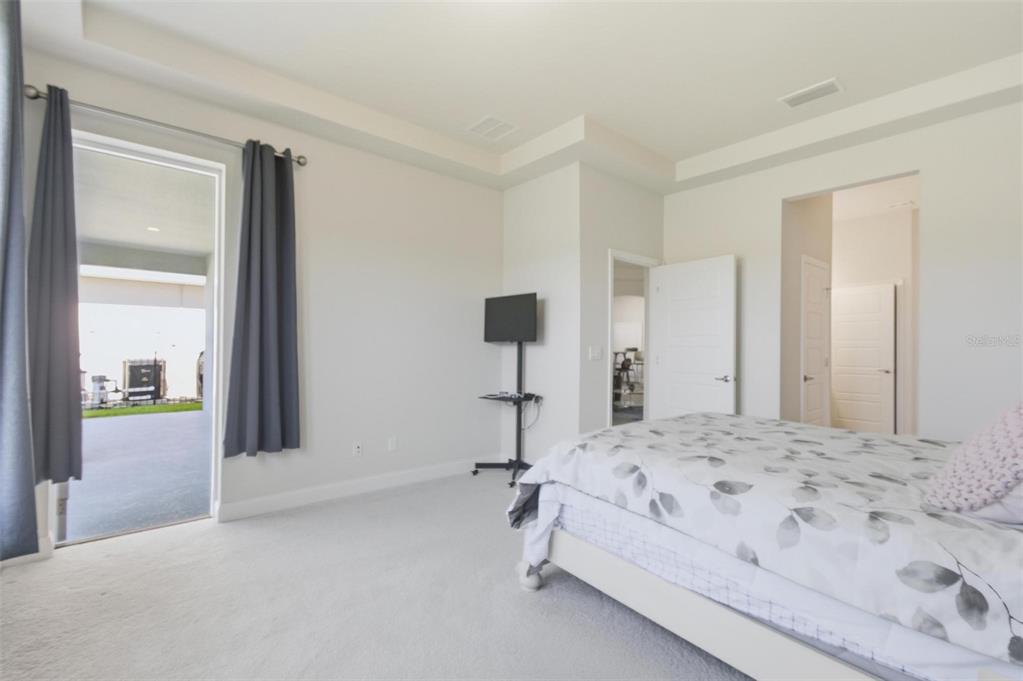 21 Spring Street Palm Coast, FL 32164 - Photo 29 of 57 a bedroom with a bed and large windows