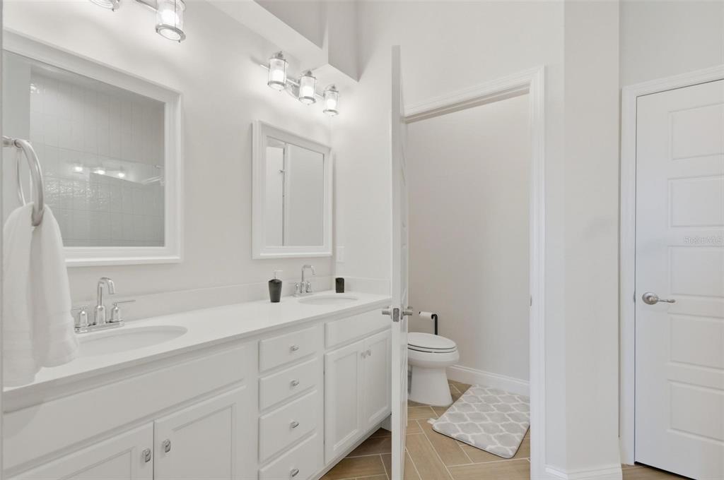 21 Spring Street Palm Coast, FL 32164 - Photo 33 of 57 a spacious bathroom with a double vanity sink toilet and a mirror