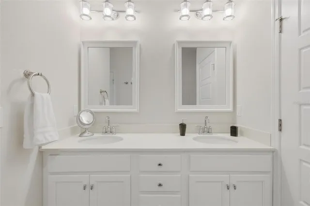 a en suite bathroom with 2 sink tub and a mirror