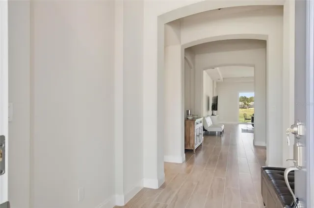 a view of a hallway with wooden floor fireplace and bathroom