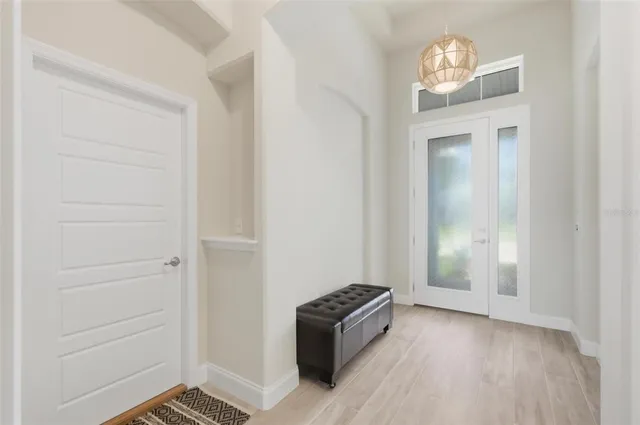 an empty room with wooden floor cabinet and hallway