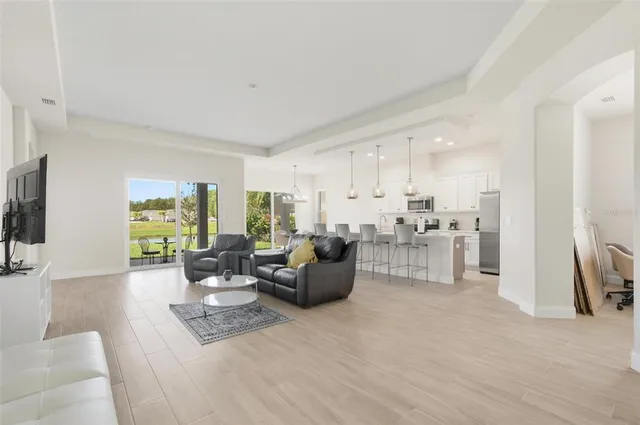 a living room with furniture white walls and a flat screen tv
