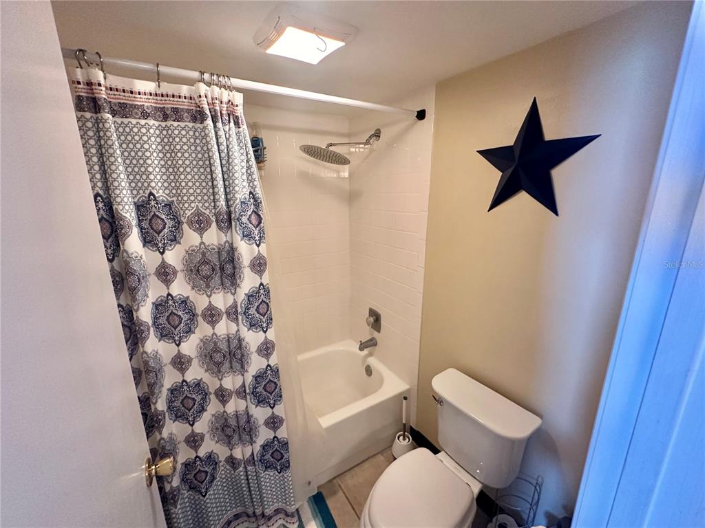 6009 Sea Ranch Drive, Unit 707 Hudson, FL 34667 - Photo 19 of 61 a bathroom with a toilet and a shower curtain