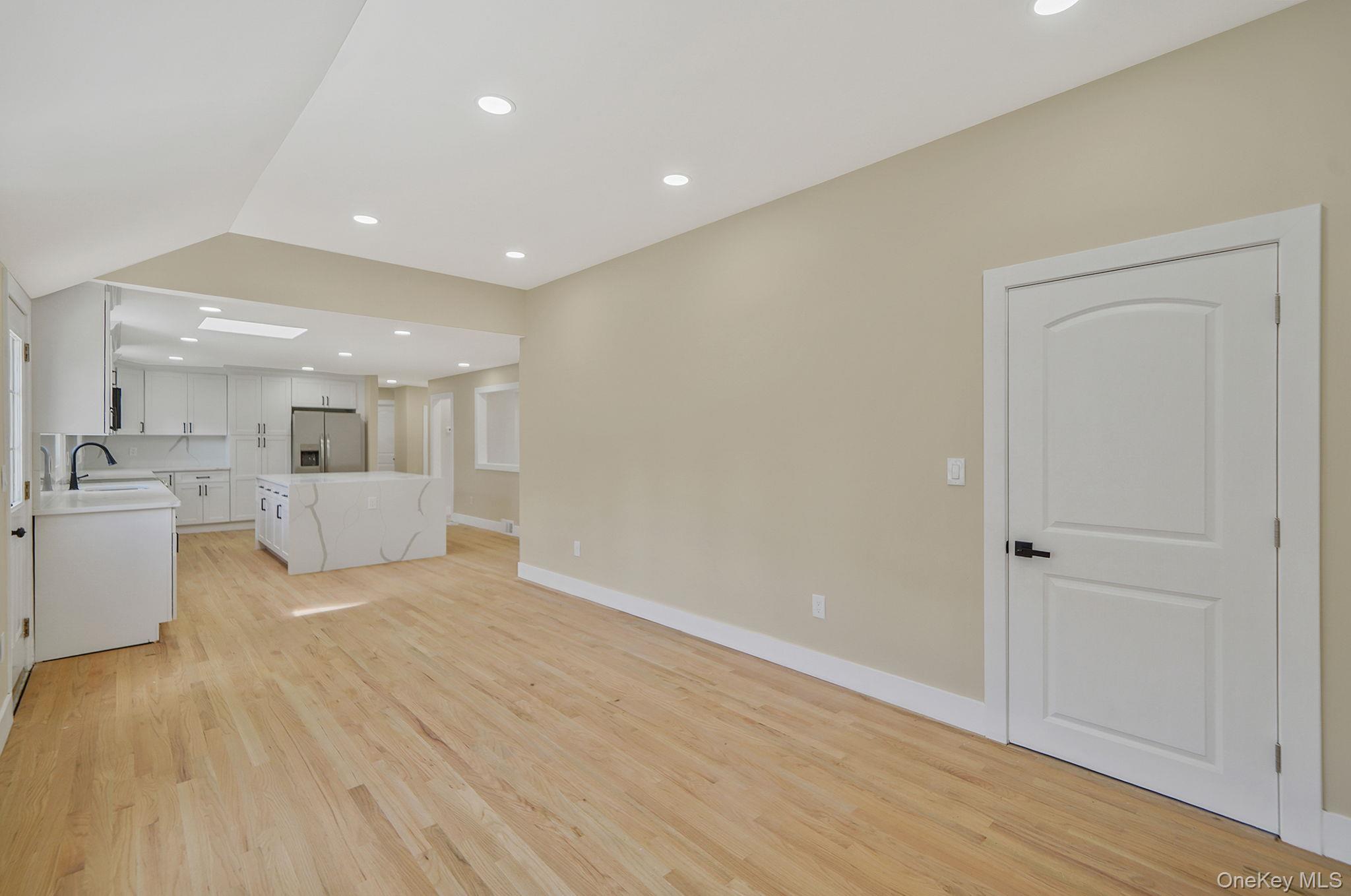 48 Vernon Street Patchogue, NY 11772 - Photo 12 of 31 Unfurnished living room with a skylight, recessed lighting, and light wood-style floors