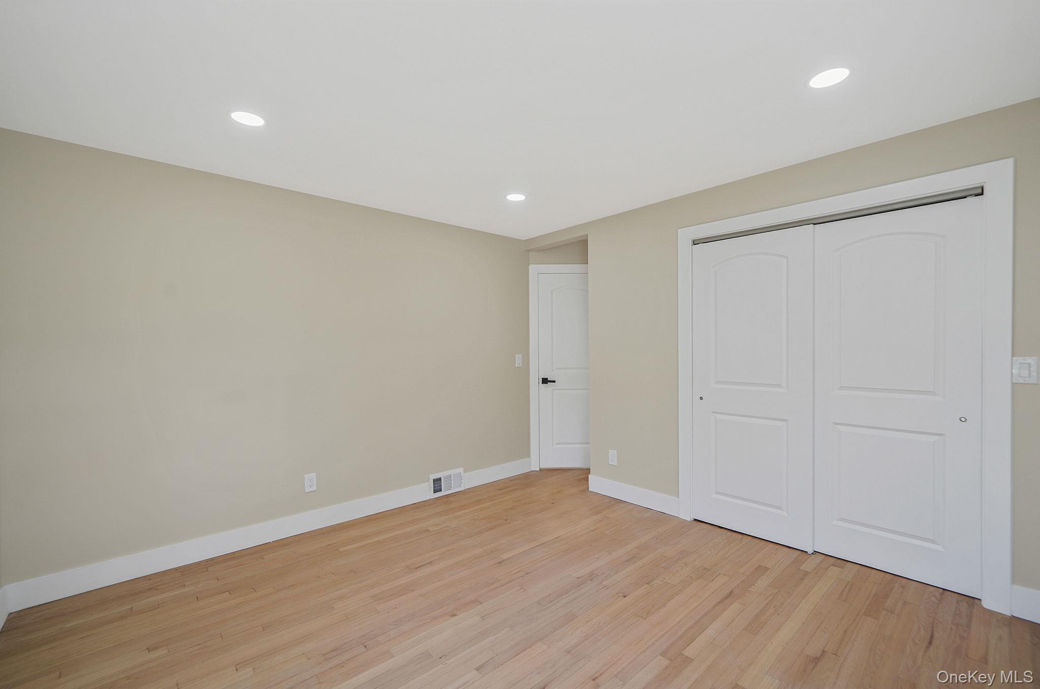 48 Vernon Street Patchogue, NY 11772 - Photo 17 of 31 Unfurnished bedroom featuring recessed lighting, light wood-type flooring, and a closet