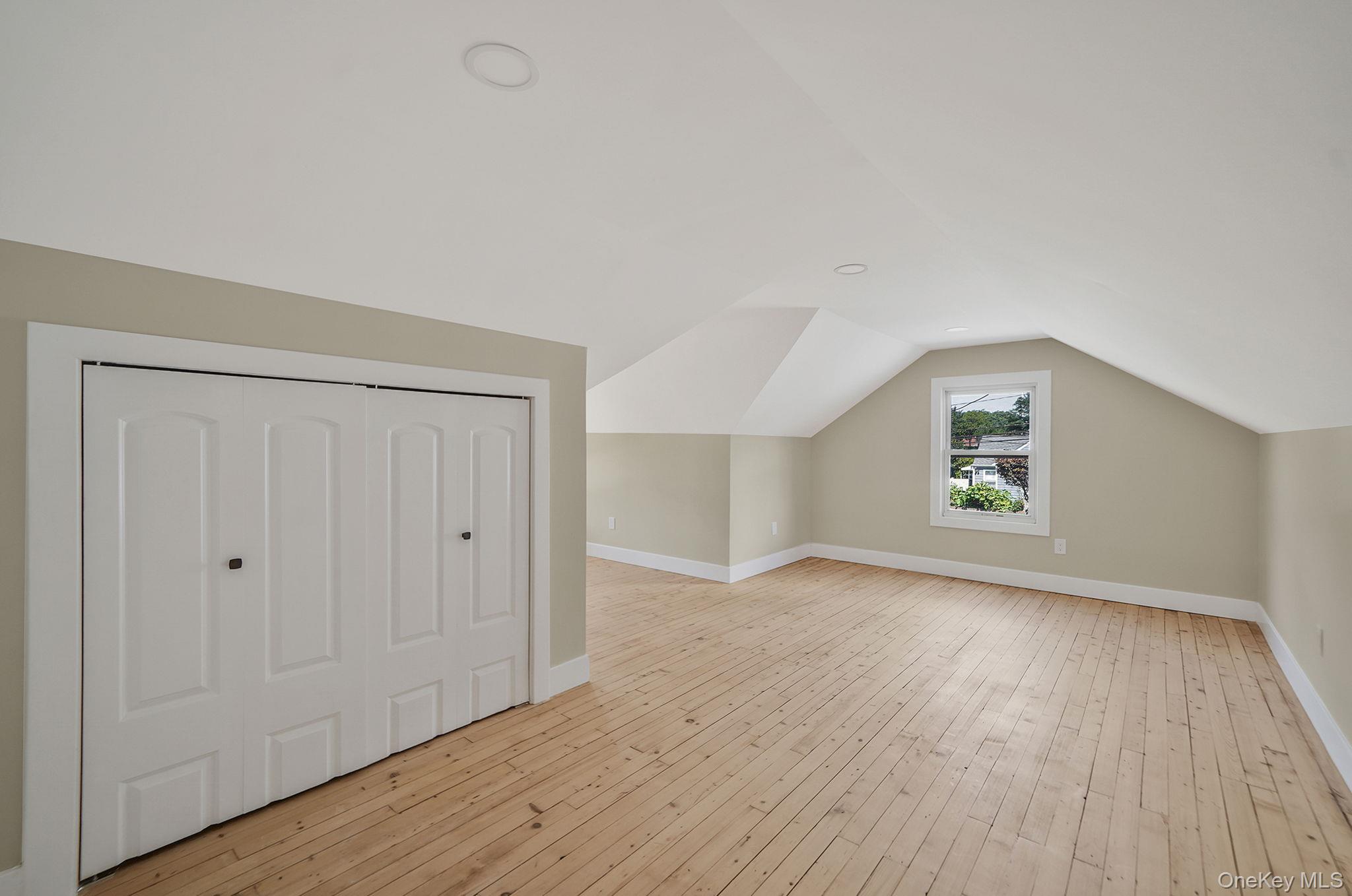 48 Vernon Street Patchogue, NY 11772 - Photo 20 of 31 Additional living space with light wood finished floors and lofted ceiling