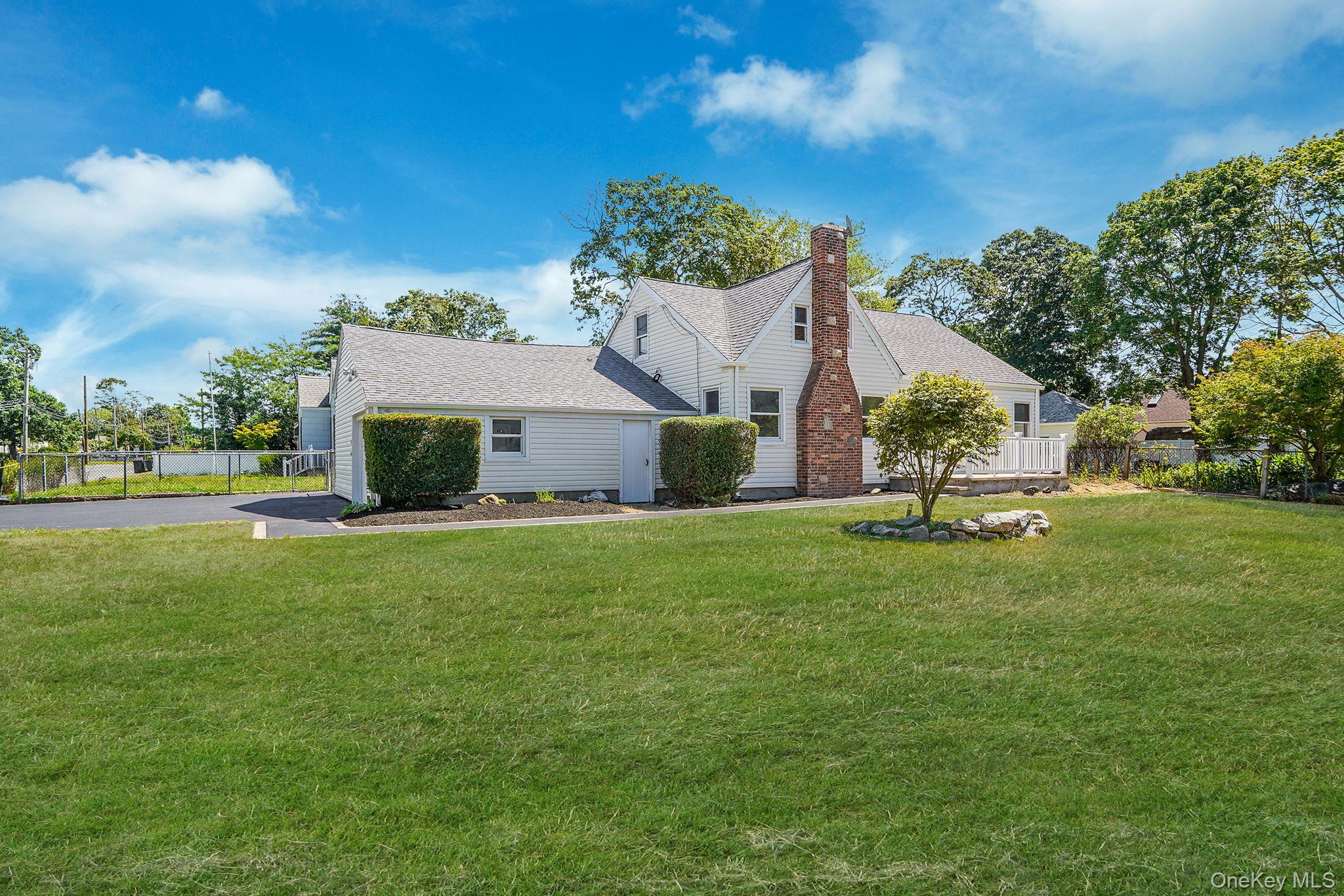 48 Vernon Street Patchogue, NY 11772 - Photo 2 of 31 View of side of home with asphalt driveway, a chimney, and roof with shingles