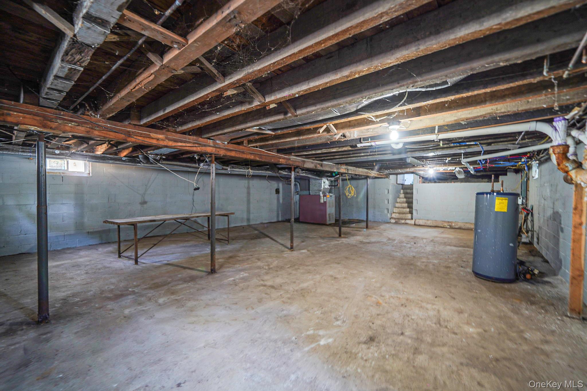 48 Vernon Street Patchogue, NY 11772 - Photo 23 of 31 Below grade area featuring stairway, water heater, and heating unit