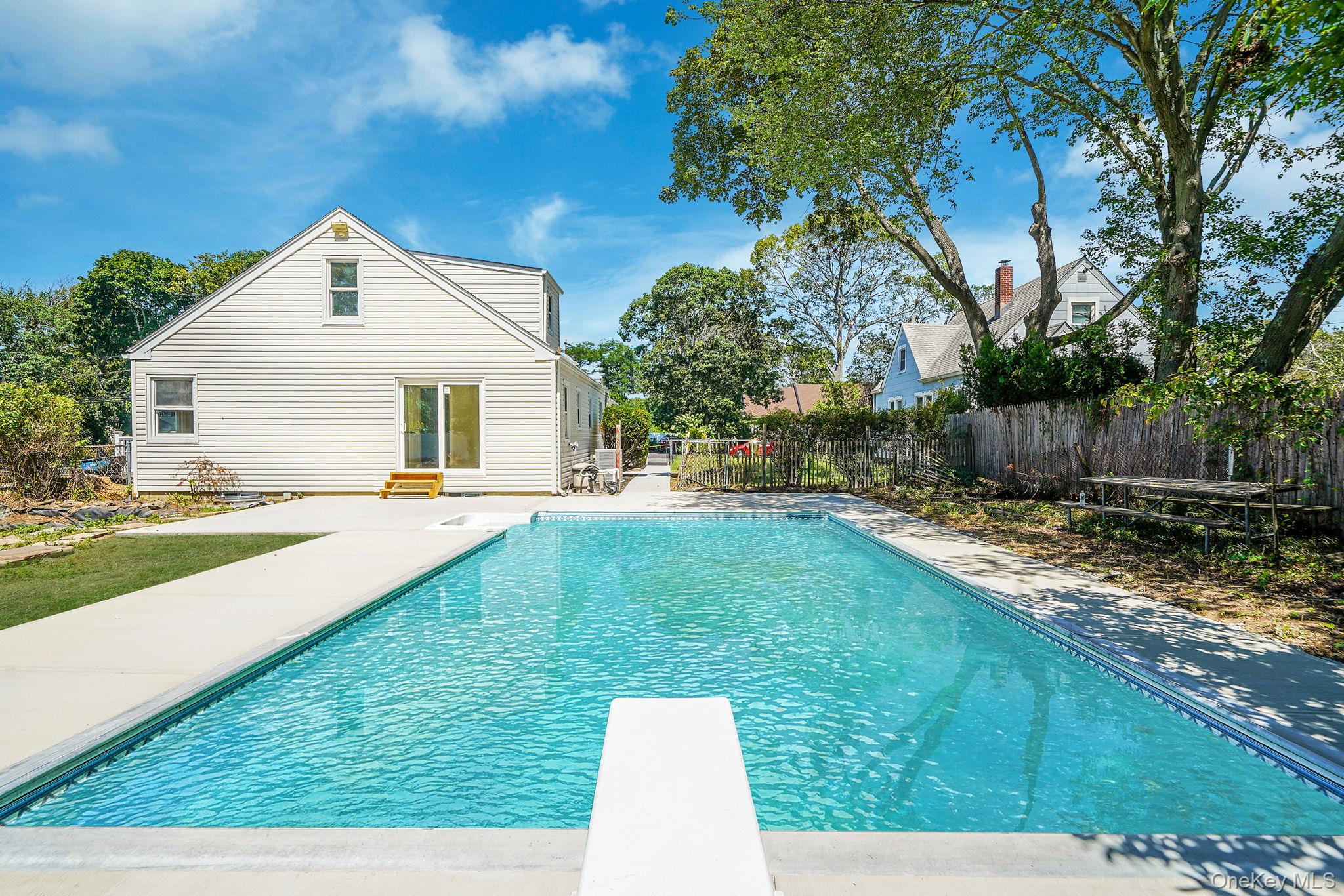 48 Vernon Street Patchogue, NY 11772 - Photo 26 of 31 View of swimming pool with a patio, a diving board, and entry steps