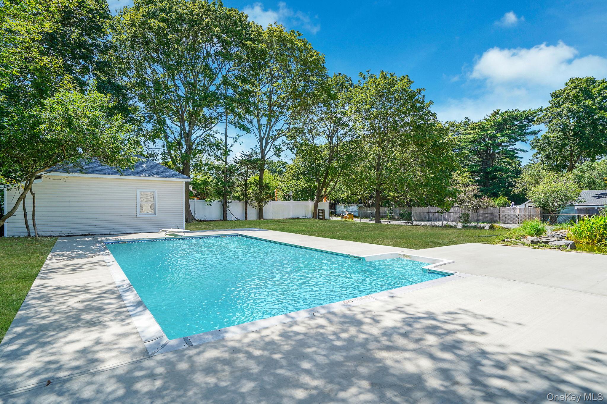 48 Vernon Street Patchogue, NY 11772 - Photo 27 of 31 View of pool with a fenced backyard, a patio area, and an outbuilding