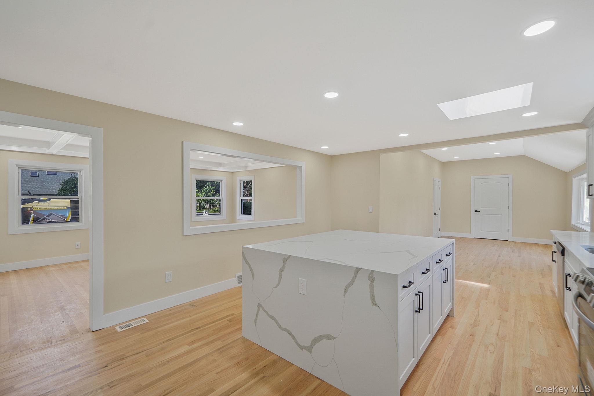 48 Vernon Street Patchogue, NY 11772 - Photo 7 of 31 Kitchen with a skylight, light stone counters, light wood-style flooring, recessed lighting, and vaulted ceiling