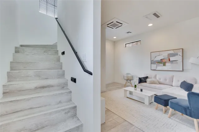 a living room with furniture and stairs