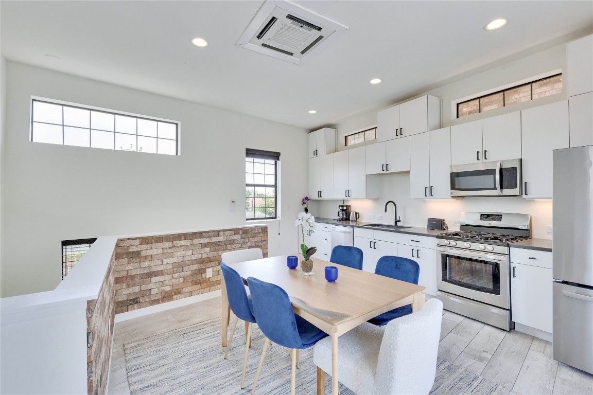 808 Lydia Street Austin, TX 78702 - Photo 18 of 40 a white kitchen with a stove a sink a dining table and chairs