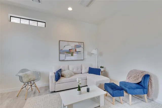 a living room with furniture a rug and a table