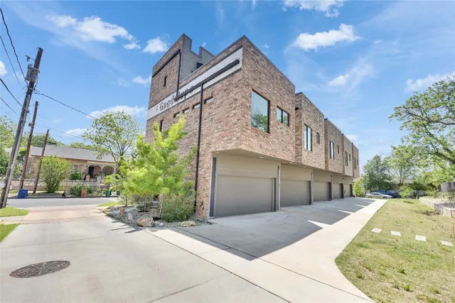 a front view of a house with a yard and potted plants