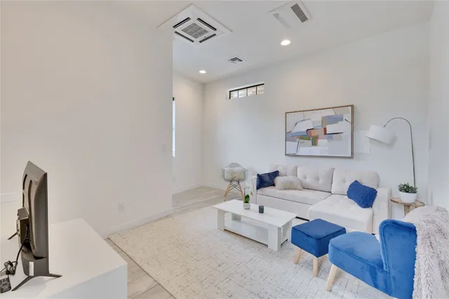 a living room with furniture a rug and a flat screen tv