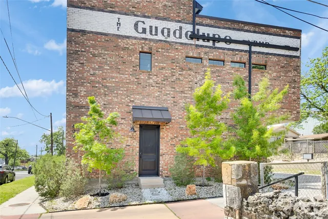 a brick house with a tree in front of it