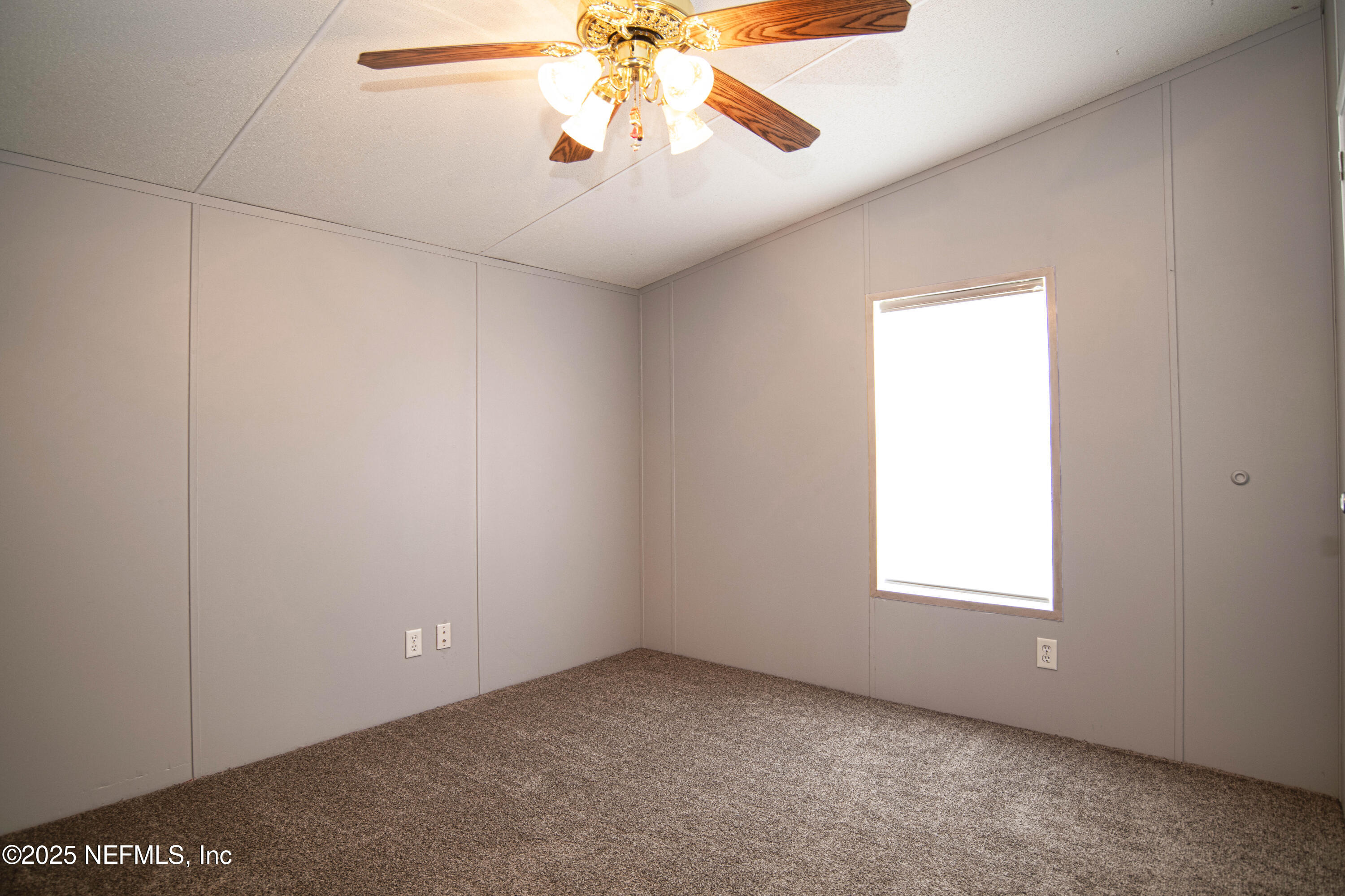 6681 Brown Road St. Augustine, FL 32095 - Photo 25 of 43 an empty room with a chandelier fan and windows