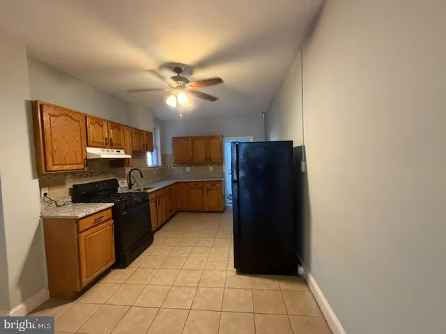 a kitchen with a refrigerator a stove top oven a washer dryer and cabinets