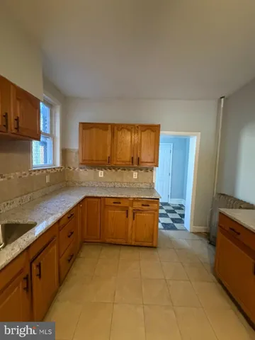 a large kitchen with granite countertop a sink a stove and a refrigerator