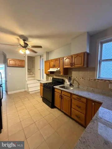 a large kitchen with stainless steel appliances granite countertop a sink and cabinets