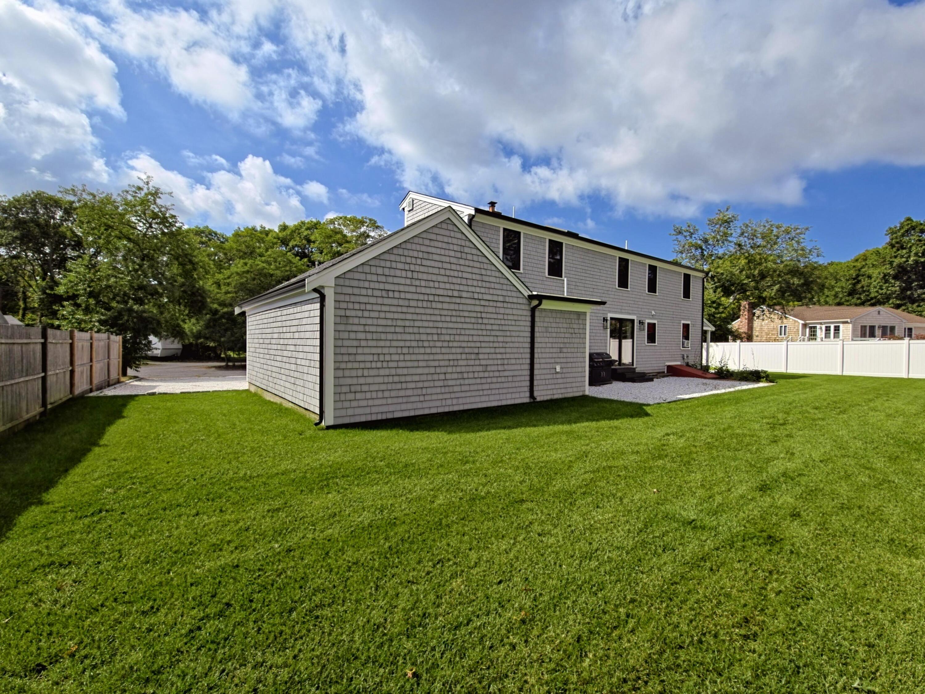 22 Keel Way Hyannis, MA 02601 - Photo 40 of 42 a backyard of a house with lots of green space and garden
