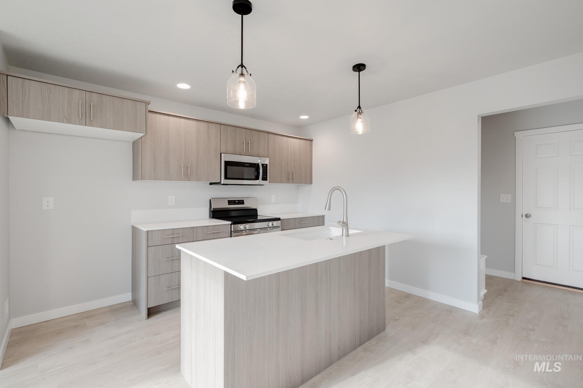 223 Moose Street Horseshoe Bend, ID 83629 - Photo 4 of 23 Kitchen featuring light brown cabinetry, modern cabinets, decorative light fixtures, appliances with stainless steel finishes, and recessed lighting