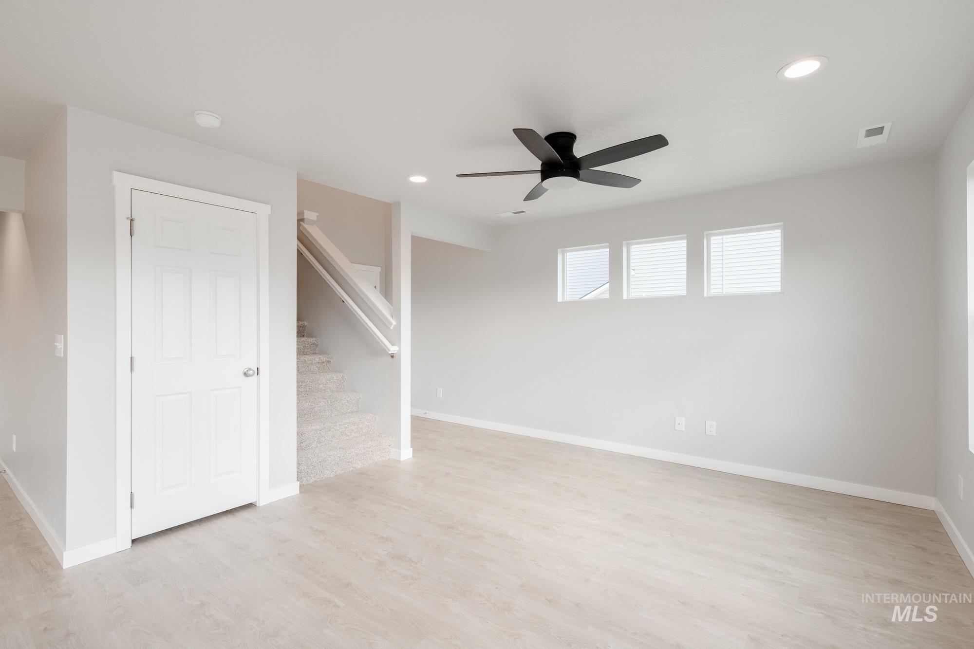 223 Moose Street Horseshoe Bend, ID 83629 - Photo 10 of 23 Empty room featuring recessed lighting, light wood finished floors, stairs, and a ceiling fan
