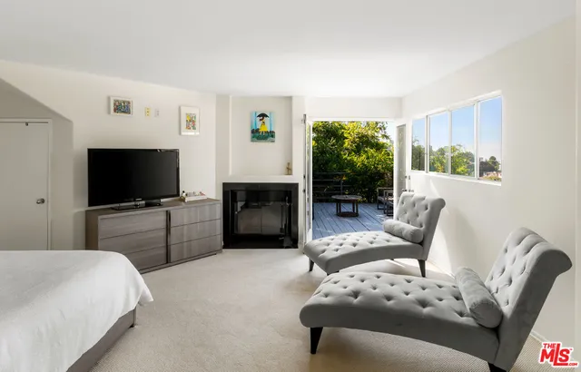 a living room with furniture a flat screen tv and a large window