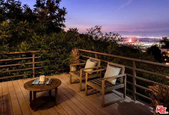 a view of a roof deck with wooden floor and city view