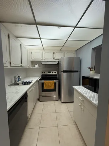 a kitchen with stainless steel appliances granite countertop a sink a stove and cabinets