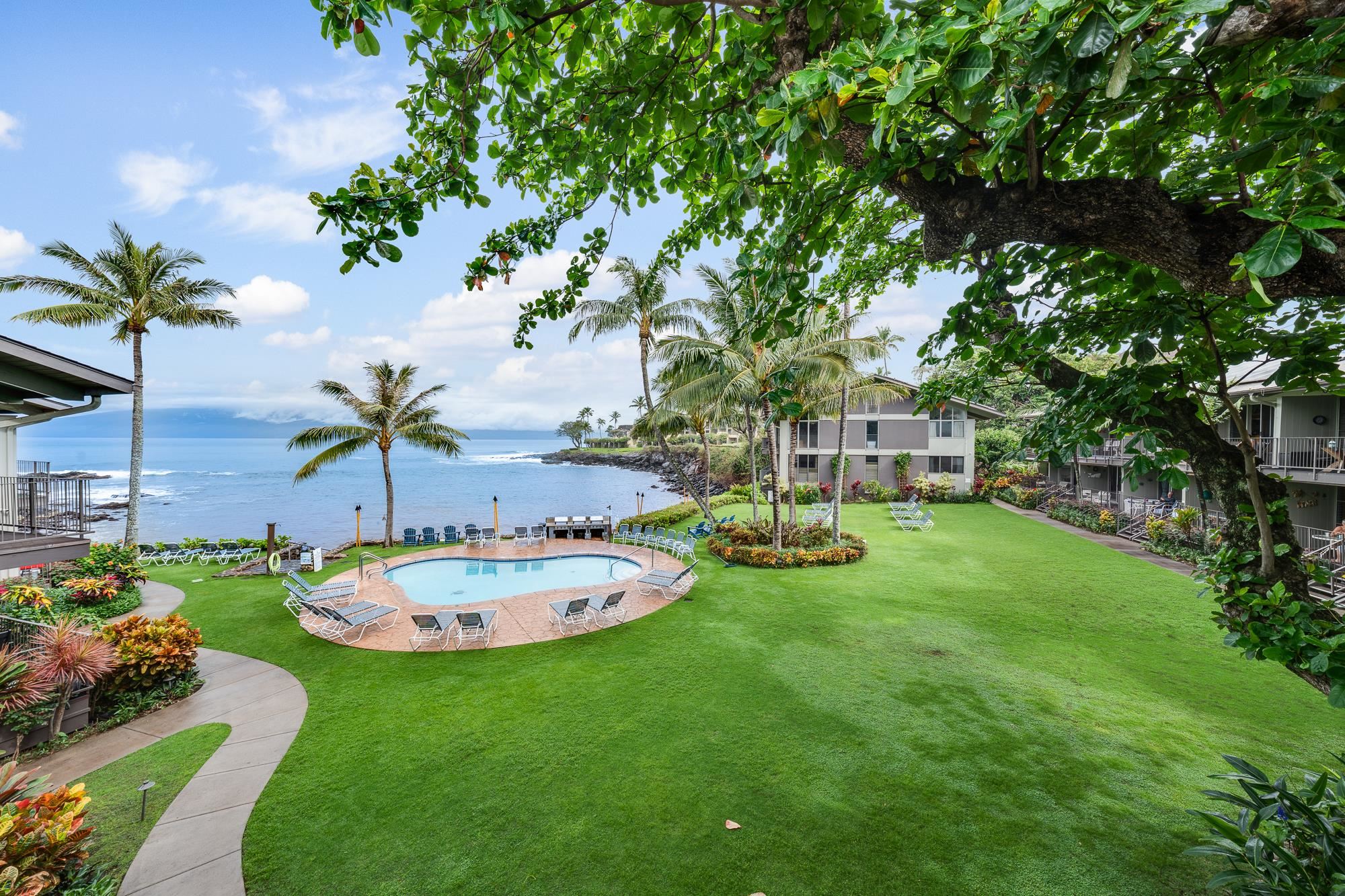 5255 Lower Honoapiilani Road, Unit 207 Lahaina, HI 96761 - Photo 1 of 49 a couple of table and chairs in the grass