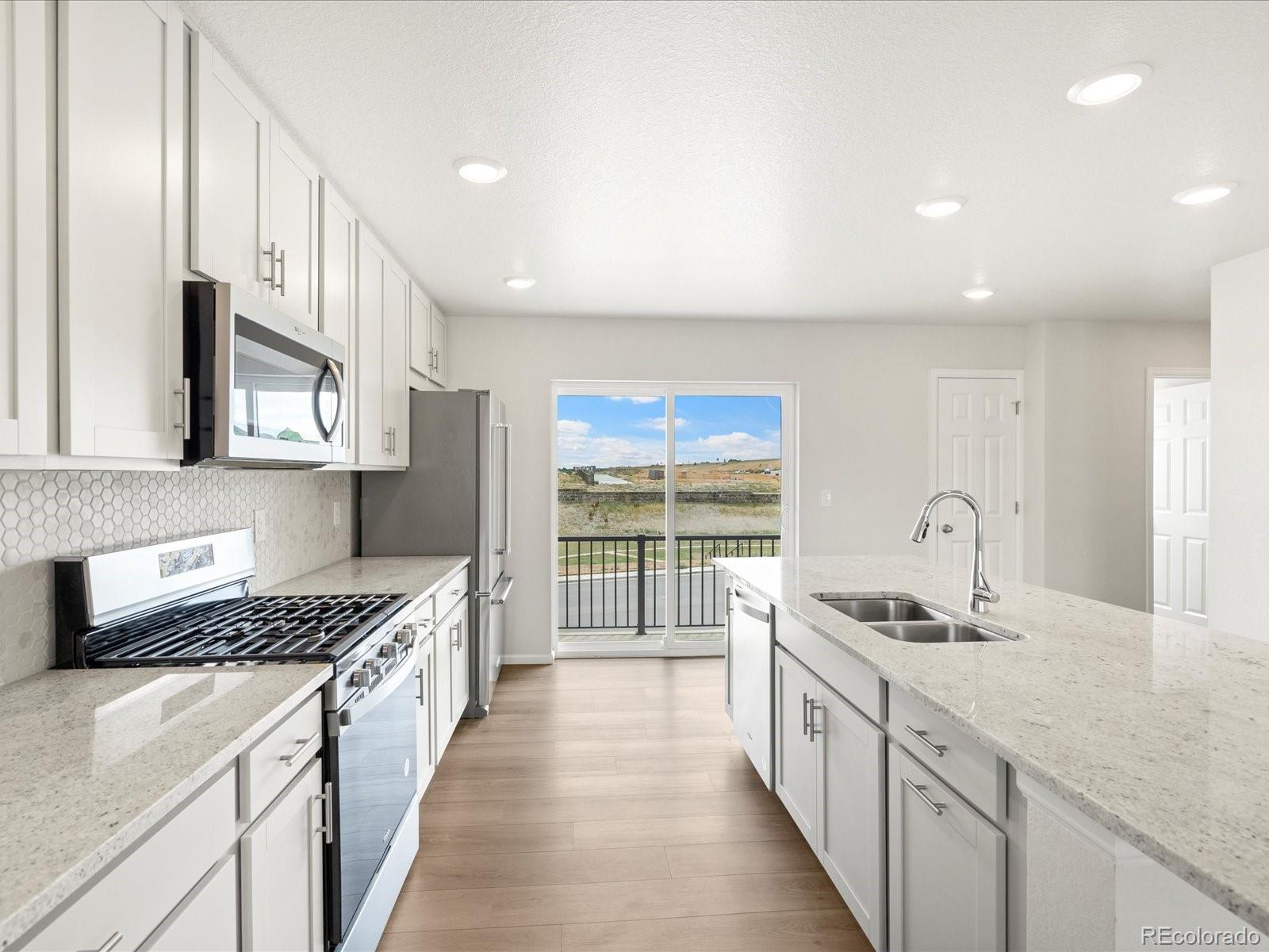 14472 Pansy Loop Morrison, CO 80465 - Photo 16 of 37 a kitchen with stainless steel appliances granite countertop a stove and a sink