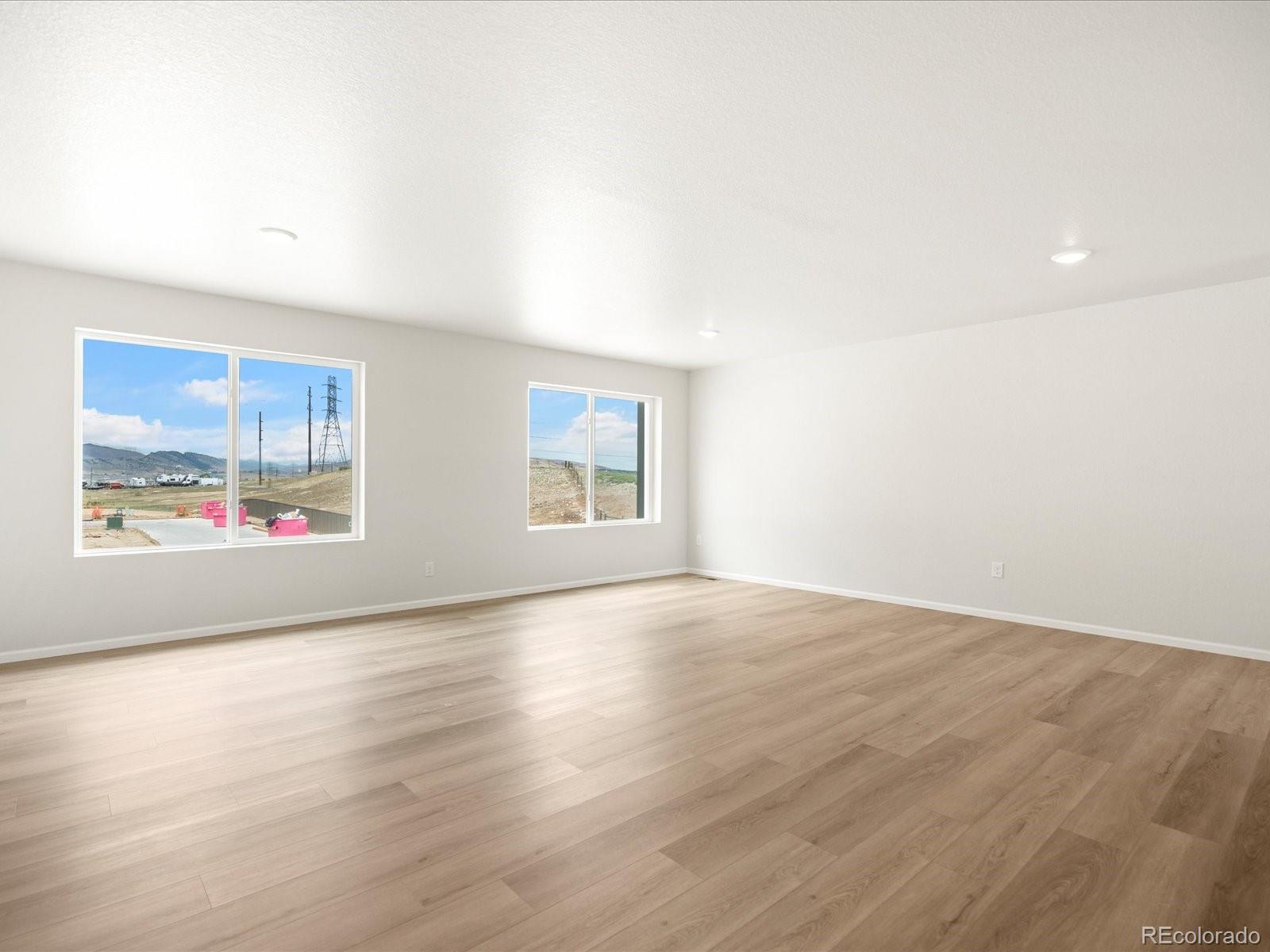 14472 Pansy Loop Morrison, CO 80465 - Photo 6 of 37 an empty room with wooden floor and windows