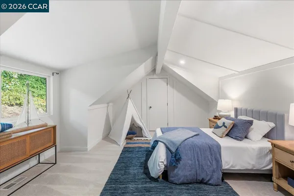 a large bedroom with a bed and wooden floor