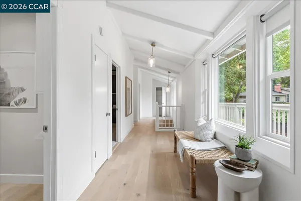 a view of a hallway with wooden floor and windows