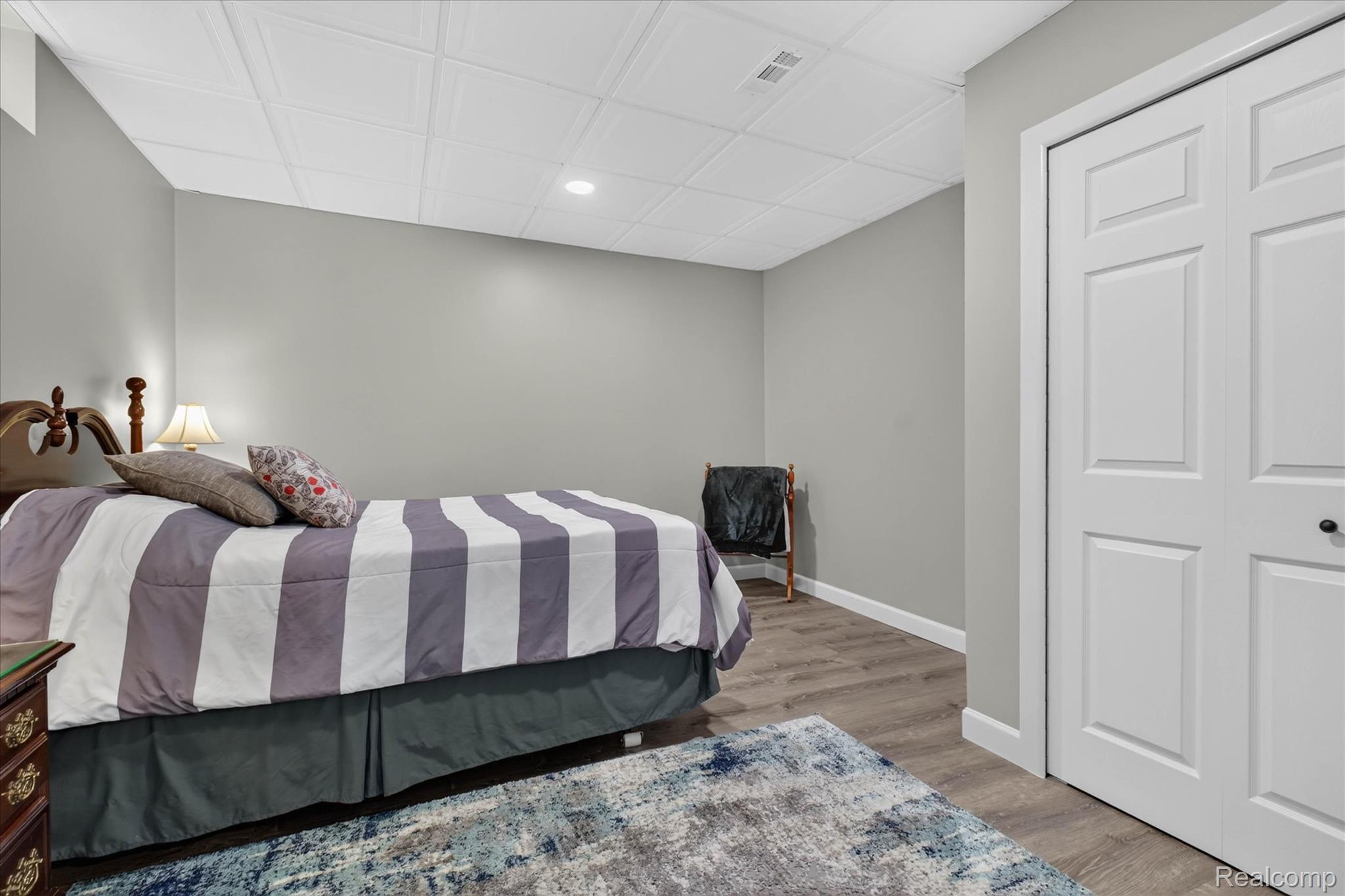 4037 Chilson Road Howell, MI 48843 - Photo 42 of 69 Spacious room featuring gray walls, wood-finish flooring, and white bi-fold closet doors