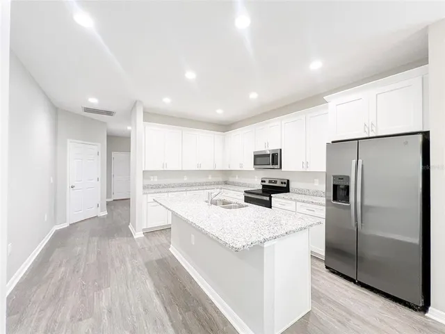 a kitchen with a refrigerator a sink and a stove top oven