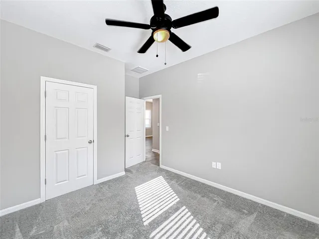 an empty room with a window and a fan