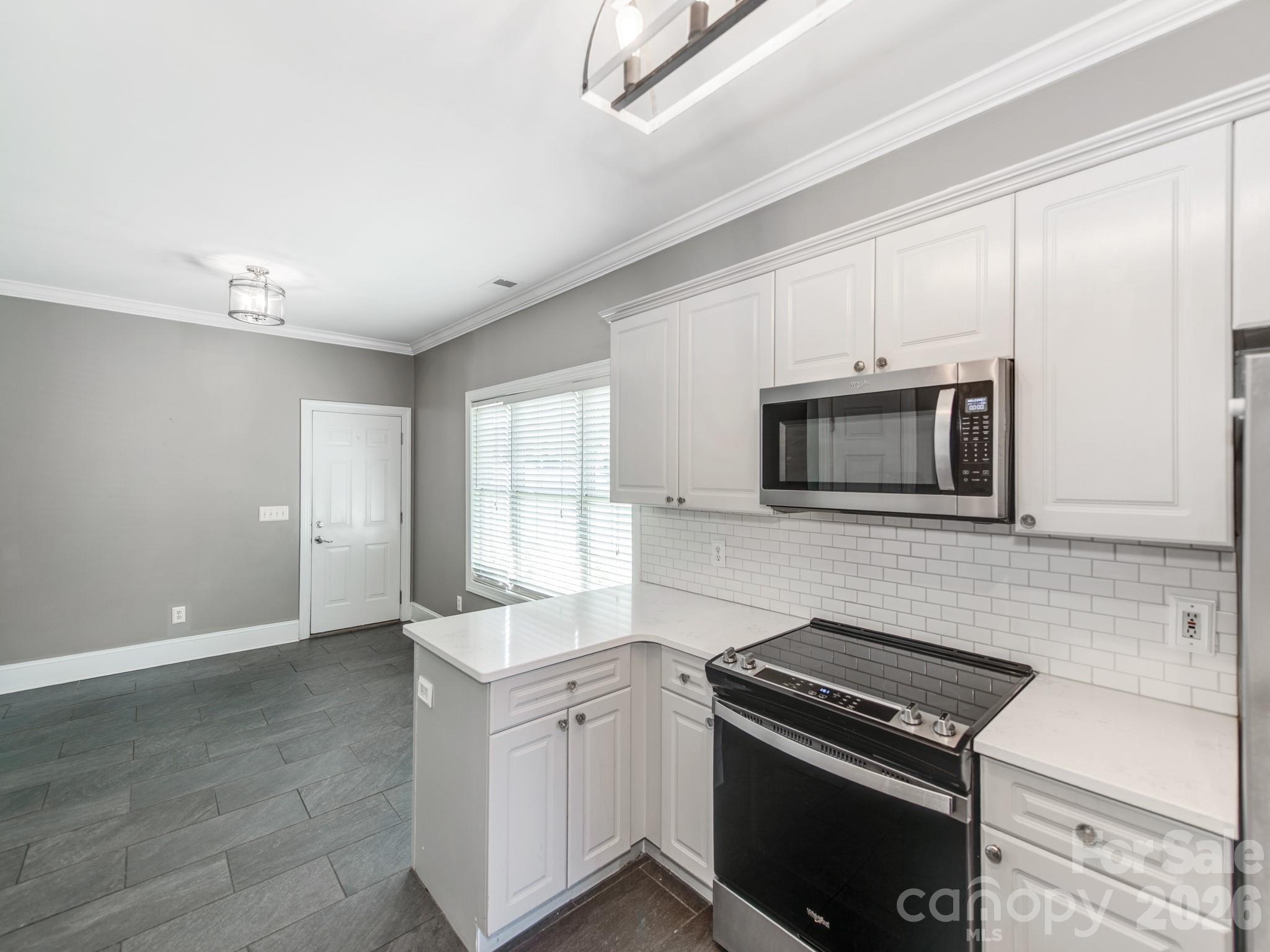 783 Sloan Street Denver, NC 28037 - Photo 8 of 44 a kitchen with stainless steel appliances white cabinets and stove