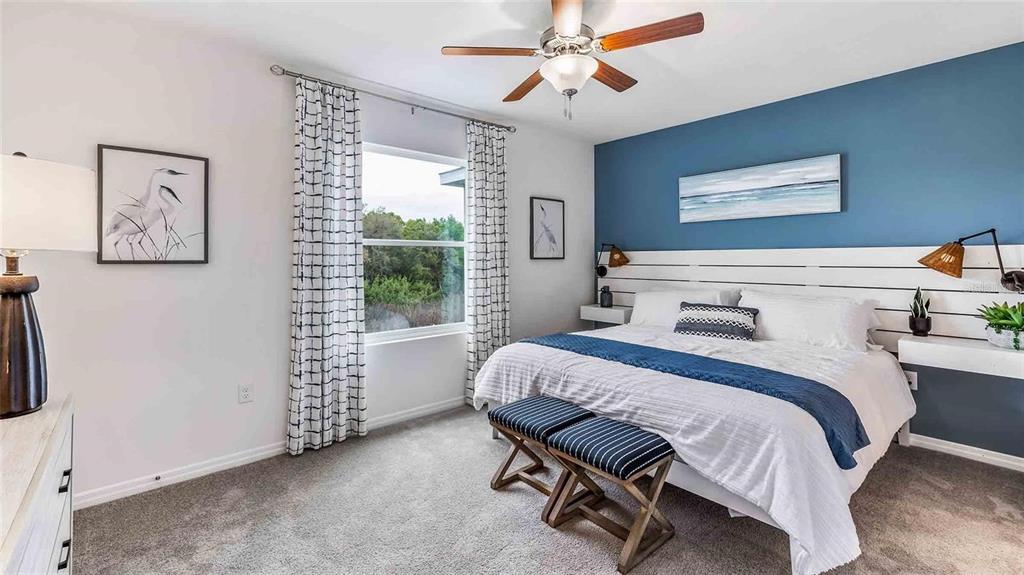 32311 Turtle Grace Loop Wesley Chapel, FL 33545 - Photo 7 of 23 a bedroom with a bed and a chandelier
