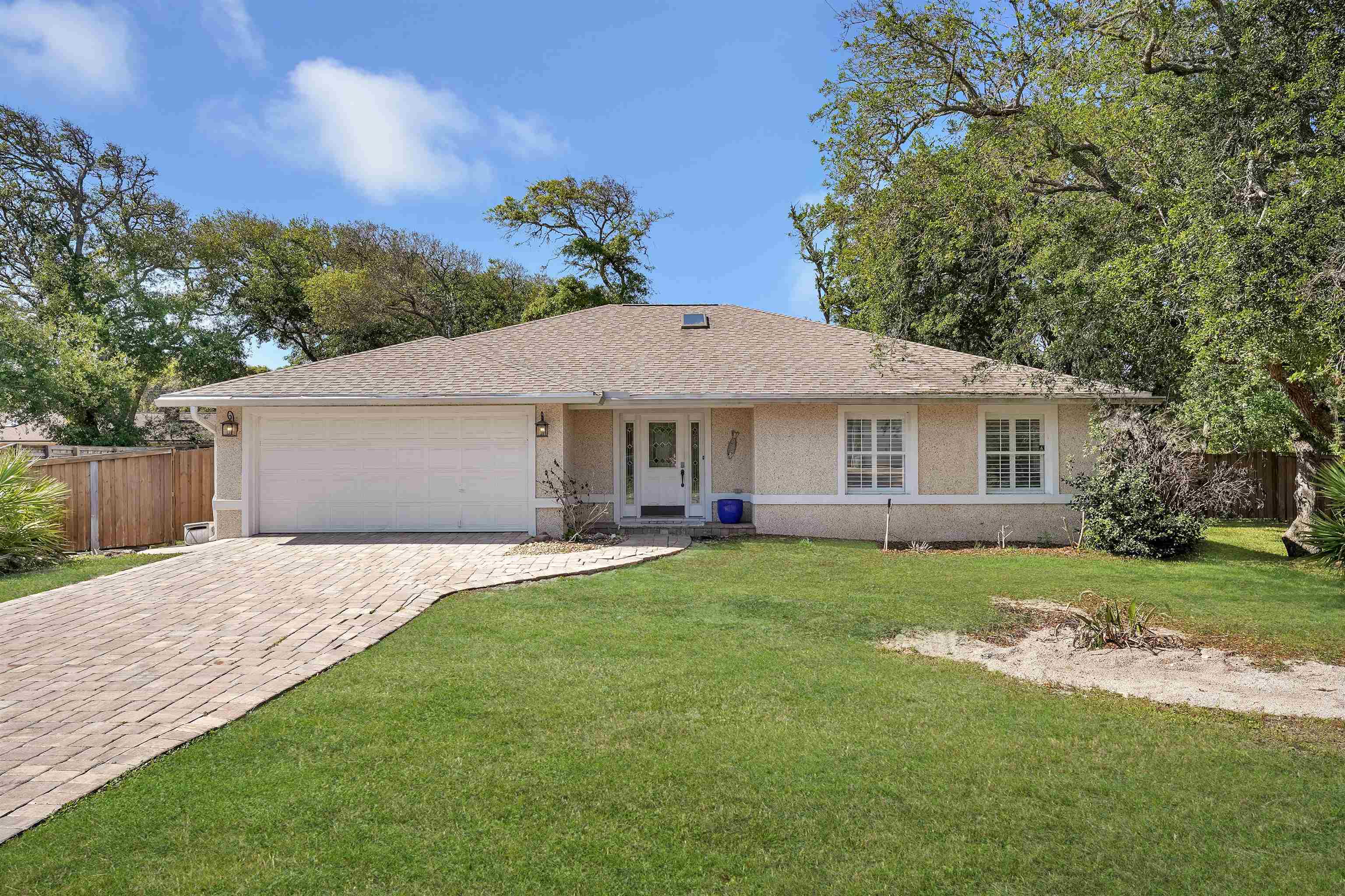 a front view of a house with a yard and trees